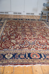 Vintage Kerman carpet border, navy blue and cherry red floral field, tattered fringe.