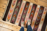 Hand knotted vintage Jijim rug with ivory, charcoal, raspberry, orange geometric bands.