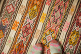 Hand-knotted vintage Jijim rug with banded stripes and intricate geometric patterns in raspberry red, orange, and beige.