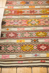 Short brown fringe and densely ornamented geometric bands on a vintage Jijim rug.