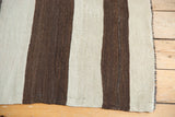 Hand woven flatweave texture of a Turkish Kilim with chocolate brown and silver bands.