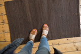 Hand-woven Turkish Kilim texture showing natural shorn chocolate brown wool with subtle tone-on-tone variations.