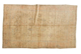 Distressed Oushak rug, faded floral palmettes and lattice vinery in ivory, gold, blush, and blue. 4'7