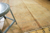 Faded allover floral patterns on distressed vintage Oushak rug with even wear.