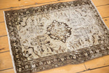 Distressed vintage Hamadan rug corner with worn pile, charcoal border, and patterned silver beige field.