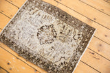 Distressed Hamadan rug corner displaying worn pile, oxidized silver, charcoal patterns, and fringe.
