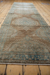 Distressed Kerman runner texture, with even wear revealing soft bronze and ocean blue.