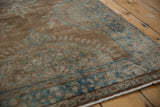 Kerman runner's distressed pile texture, revealing faded bronze and ocean blue floral patterns.