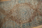 Distressed Kerman runner showing pale bronze, ocean blue floral roundel, and mostly even wear to knot heads.