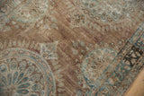 Distressed Kerman rug pile showing pale bronze and ocean blue floral motifs.