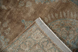 Distressed antique Kerman rug pile in brown and blue, revealing its woven foundation.