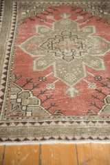 Distressed Oushak rug pile texture with geometric border, dark blush red, and mostly even wear.