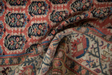 Antique Kurdish runner showing intricate geometric border in cinnabar, ivory, and teal.
