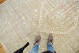 Distressed Oushak rug showing subtle tone-on-tone pattern in earthen tones.
