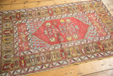 Vintage Melas rug corner: brick red central field, foundation wear, and geometric bronze border.