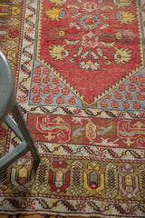 Melas rug lower border with pale bronze, cinnabar, ivory, and blue blossomed bud motifs.