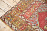 Vintage Melas rug: cinnabar red field, pale bronze border with geometric designs, showing wear.