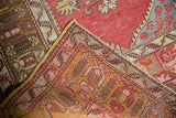 Vintage Melas rug folded corner reveals hand-knotted texture, red field wear, and yellow edge.