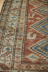Vintage Kurdish runner showcasing woven animal motifs and geometric border patterns.