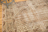 Time-softened ivory, blush, and brown tones of the distressed Malayer carpet's intricate field.