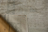 Vintage distressed Oushak carpet corner showing reverse foundation with painted numbers and soft pile.