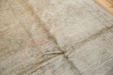 Muted silver, blush, and ivory tones on the distressed Oushak rug's textured pile.