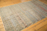 Distressed Oushak rug with faded floral trellis, revealing colorful wefted red and blue threads.