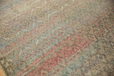 Distressed Oushak rug with softened pile, faded floral trellis, and colorful weft lines.