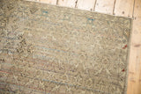 Distressed Oushak rug corner, showing faded beige floral trellis and subtle poly-chromatic weft.