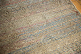 Close-up of distressed vintage Oushak rug pile with faint floral trellis and colorful wefts.