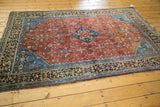 Vintage Qashqai rug corner, intricate bronze charcoal border, ruby red Herati field.