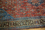 Qashqai rug corner, intricate ruby red Herati field, sapphire blue spandrel, bronze border.