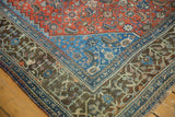 Corner detail of vintage Qashqai rug showcasing gem-toned floral motifs in blue, red, and charcoal.