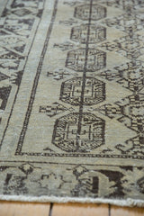 Geometric guls and charcoal wide border on a distressed beige Oushak runner.