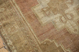 Distressed geometric stepped contour on a vintage Oushak rug in dusty plum and beige.