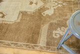 Vintage Distressed Oushak rug with patterned border, showing low pile and warm bronze-beige tones.