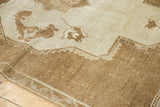 Detail of vintage distressed Oushak carpet showing primitive drawing, pale bronze, and chocolate tones.