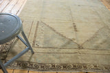 Distressed Oushak rug corner with faded chocolate brown geometric border.