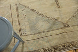 Vintage Oushak carpet corner, distressed pile with zigzag motifs, pale gold, beige, slate tones.