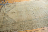 Distressed Oushak carpet with faded medallion and field, featuring pale gold, beige, and slate gray tones.