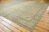 Distressed Oushak rug section with faded ivory, sea foam, and brown boteh pattern.