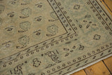 Distressed vintage Oushak carpet corner with ivory, sea foam boteh motifs and visible foundation wear.