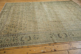 Distressed Oushak carpet corner with pale sea foam green border and visible foundation wear.