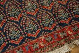 Vintage Malayer runner: close-up of navy boteh and germinating flowers, red border, low pile.