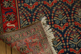 Vintage Malayer rug corner with navy and red boteh, low pile, fringe, and woven back.