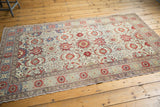 Corner of distressed vintage Kayseri rug: ivory field, cinnabar palmettes, Herati motifs.