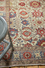 Vintage distressed Kayseri rug's lower border with red palmettes, blue, and faint foundation showing.