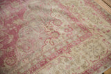 Distressed Sivas carpet detail, showcasing faded fuchsia, ivory, and scrolling vinery texture.