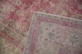 Distressed Sivas rug pile with faded fuchsia and visible foundation, revealing woven backing.