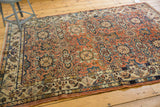 Vintage Malayer carpet corner showcasing floral field and alternating minor border patterns.